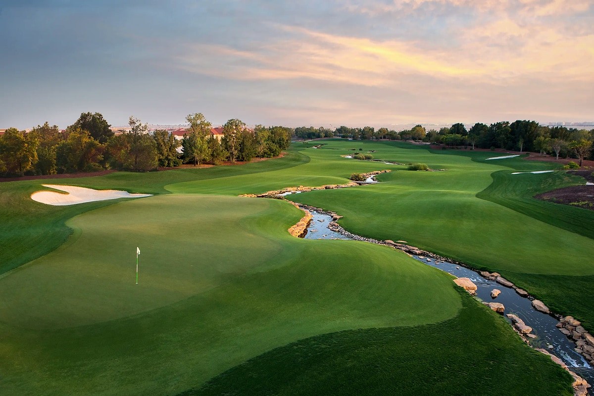 Golf course with a stream at sunset in Jumeirah Golf Estates